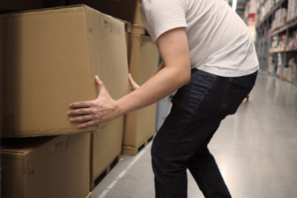 Homme se baissant pour porter un carton